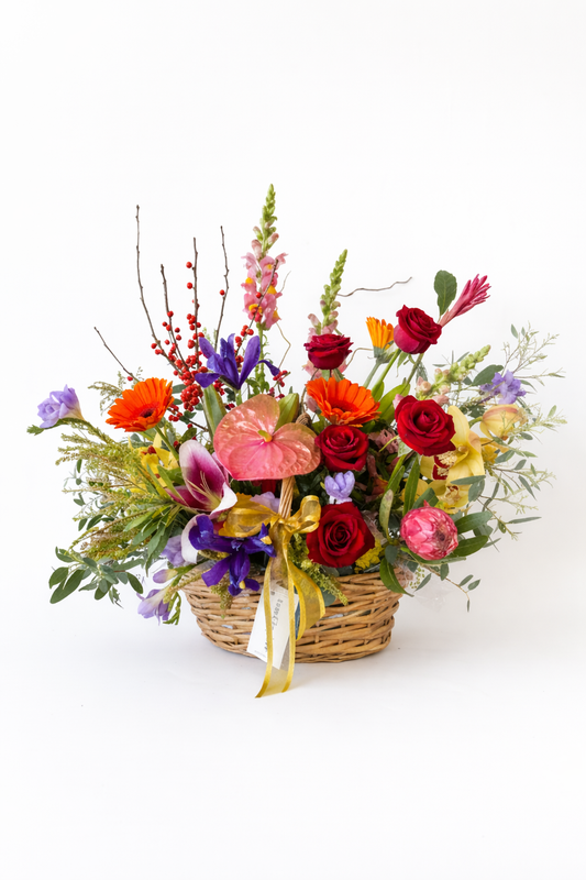 Colorful flower arrangement in a basket on a white background